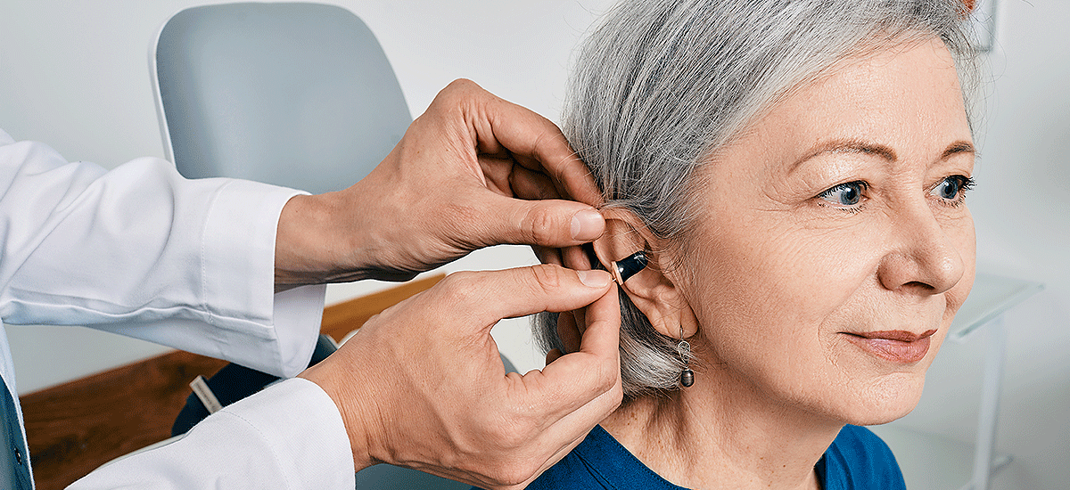 mature woman getting hearing aids at a hearing clinic